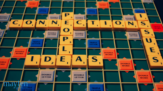 Scrabble board with interconnecting words; connections, issues, people, ideas